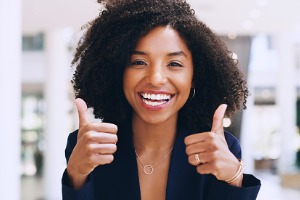 Woman smiling and holding two thumbs up
